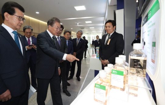 세포 치료제 원료 배양  살펴보는 文대통령 문재인 대통령이 22일 충북 청주시 오송 CV센터에서 열린 '바이오헬스 국가비전 선포식'에 앞서 본행사장 앞 로비에 설치된 ㈜엑셀세라퓨틱스 부스에서 세포 치료제 생산의 원료 물질인 배양 배지를 살펴보고 있다.    연합뉴스